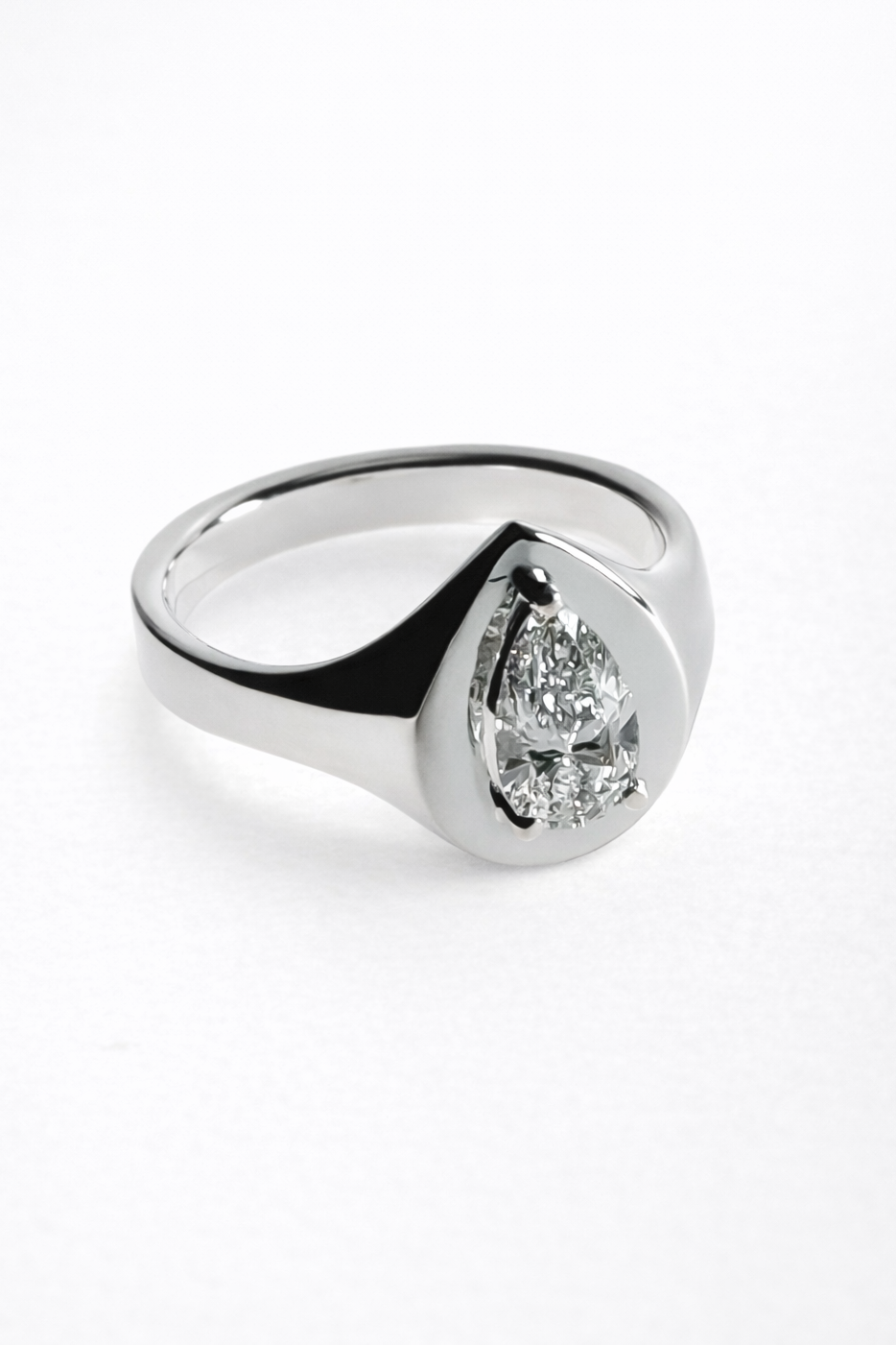 Silver ring with a pear-shaped diamond on a white background